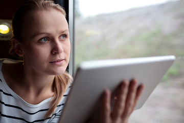 Image showing Woman traveling on a train with tablet