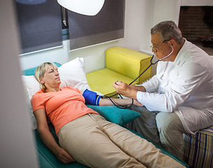 Image showing Doctor measuring blood pressure of woman at home