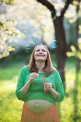 Image showing Happy pregnant woman and bubbles outdoor