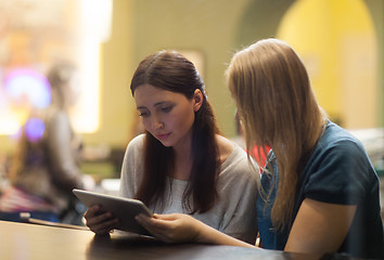 Image showing Two women in the restaurant using electronic tablet