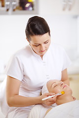 Image showing Cosmetician applying a facial mask using brush