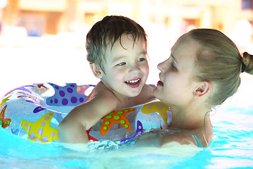 Image showing Mother and her son in the outdoor swimming pool