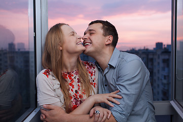 Image showing Young couple on the balcony embracing and laughing