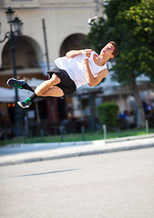 Image showing Young man performing somersault in the street