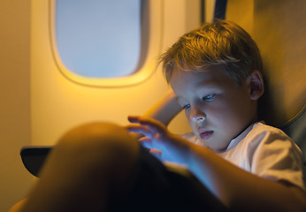 Image showing Little boy using tablet computer during flight