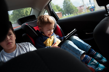 Image showing Two boys on the back seat of a car