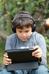 Image showing Teen boy in headphones with pad