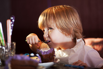 Image showing Little boy eating chocolate cake