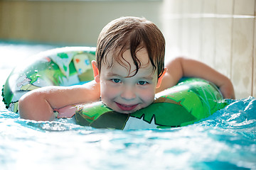 Image showing Young boy in inflatable tube swimming