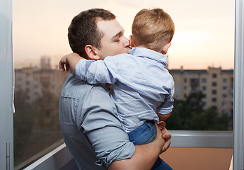 Image showing Father kisses his son on the balcony