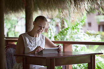 Image showing Smiling woman using tablet computer in cafe during vacation