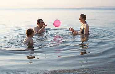 Image showing Young family playing with ball at sunset