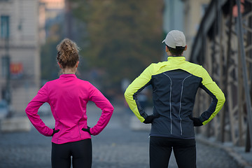 Image showing couple warming up before jogging