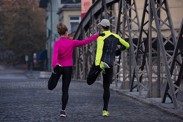 Image showing couple warming up before jogging