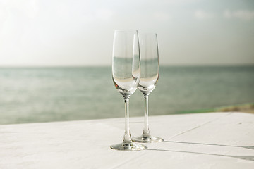 Image showing  close up of two champagne glasses on beach 