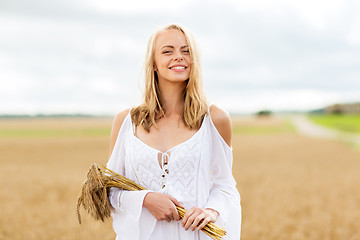 Image showing happy young woman with spikelets on cereal field