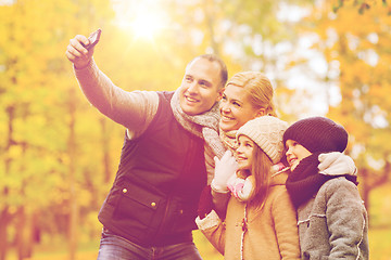 Image showing happy family with camera in autumn park