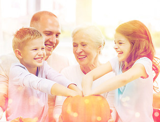 Image showing happy family sitting with pumpkins at home