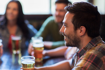 Image showing happy friends drinking beer at bar or pub