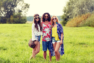 Image showing smiling young hippie friends on green field