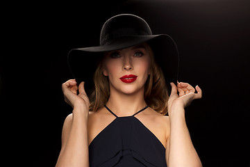 Image showing beautiful woman in black hat over dark background