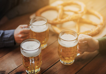 Image showing close up of hands with beer mugs at bar or pub