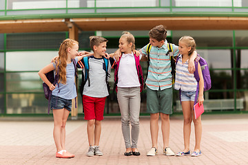 Image showing group of happy elementary school students hugging