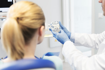 Image showing close up of dentist showing teeth model to patient