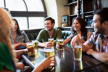 Image showing happy friends drinking beer at bar or pub