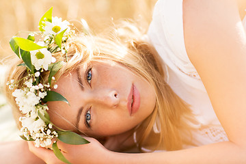 Image showing happy woman in wreath of flowers on cereal field