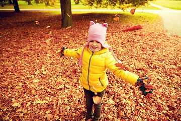 Image showing happy girl playing with autumn leaves in park