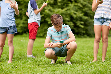 Image showing kids with smartphones playing game in summer park