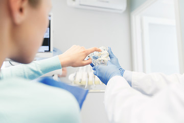 Image showing close up of dentist with teeth model and patient
