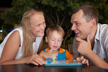 Image showing Happy family with tablet PC outdoor in the evening