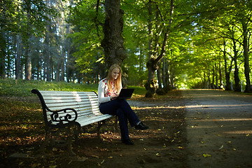 Image showing Young woman with laptop in the park