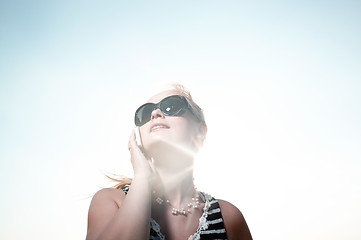 Image showing Talking on the phone with sun behind