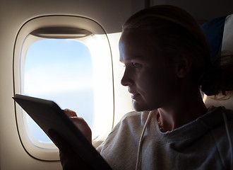 Image showing Woman sitting by illuminator in plane with touch pad