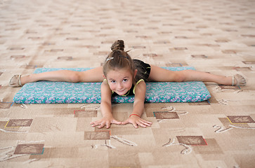 Image showing Little girl doing leg-split on the floor