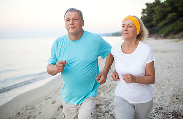 Image showing Senior couple jogging on the coast