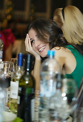 Image showing Happy smiling woman sitting at a bar counter