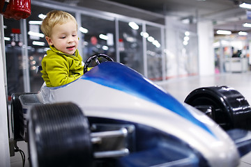 Image showing Little boy driving a racing car