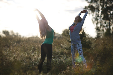 Image showing Two young women working out in the garden