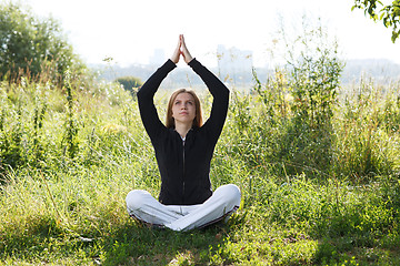 Image showing Young woman practicing yoga in the city park