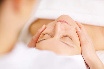 Image showing Woman under professional facial massage in beauty spa