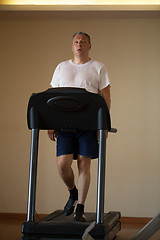 Image showing Middle-aged man working out on a treadmill