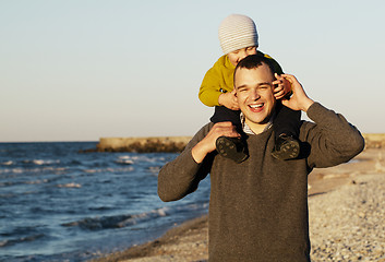 Image showing Laughing father giving his sonny a piggy back