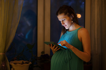 Image showing Pregnant woman using tablet in the evening