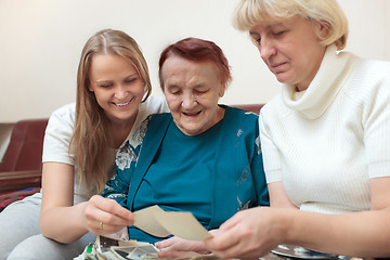 Image showing Mother, daughter and grandma looking at photos
