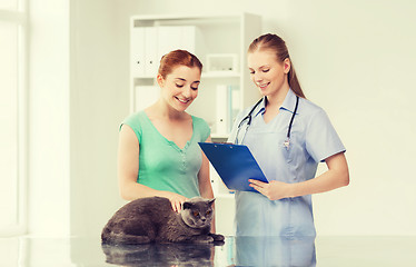 Image showing happy woman with cat and doctor at vet clinic