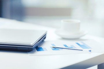 Image showing close up of laptop computer, charts and coffee